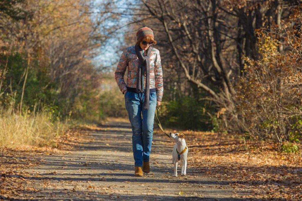 Woman walking dog woods02